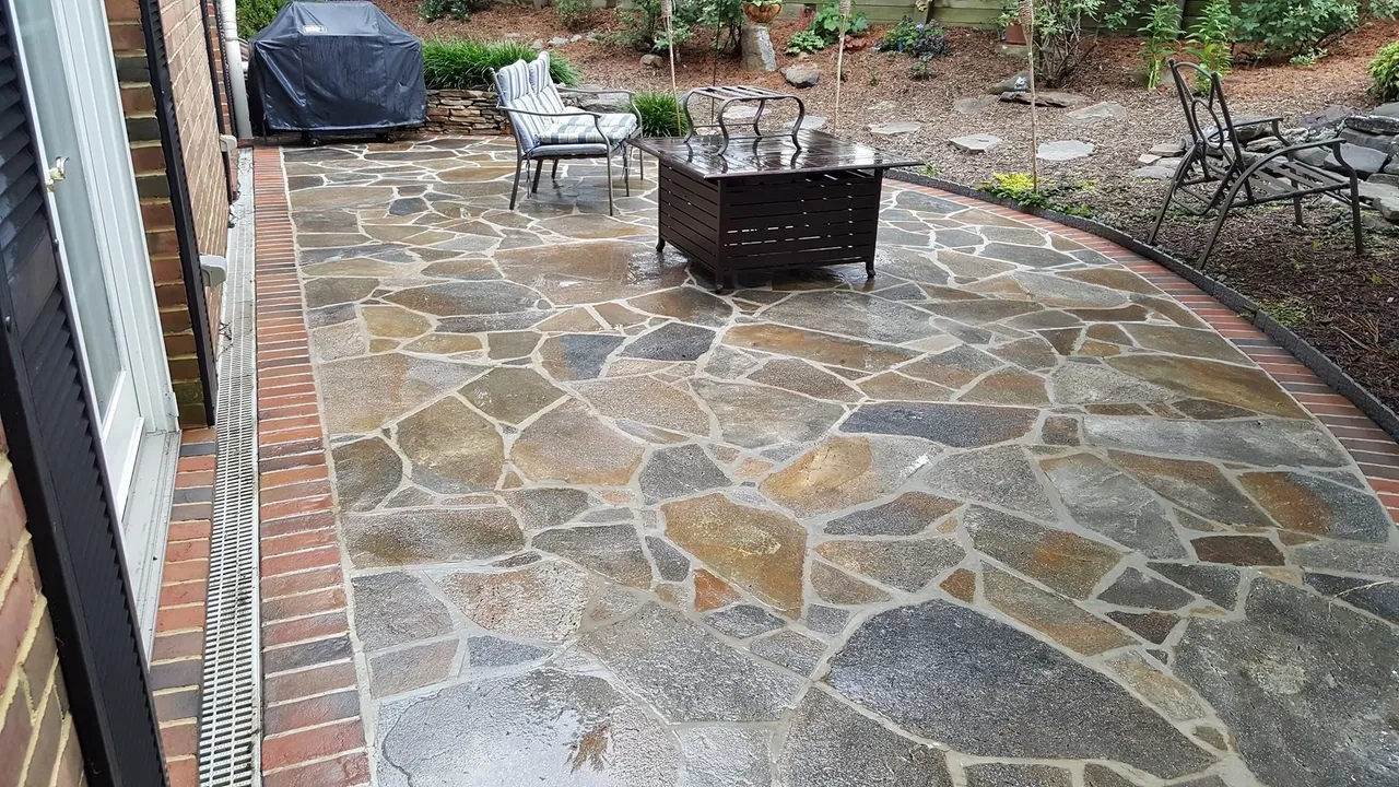 Stone patio with grill and chairs