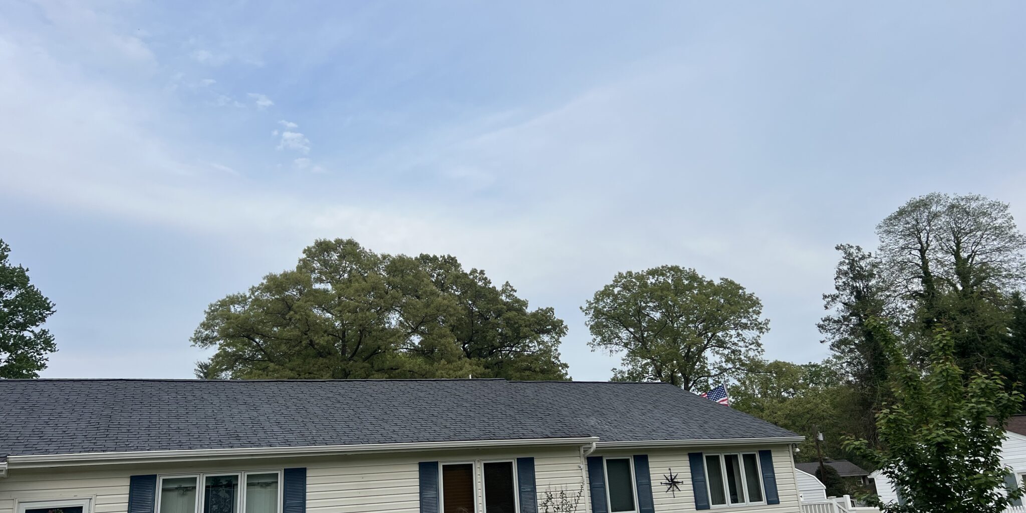 Single-story house with a dark roof under a clear sky.